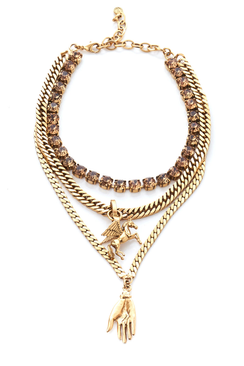 A gold-toned necklace with layered chains and a phoenix charm alongside a hand pendant.