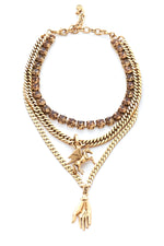 A gold-toned necklace with layered chains and a phoenix charm alongside a hand pendant.