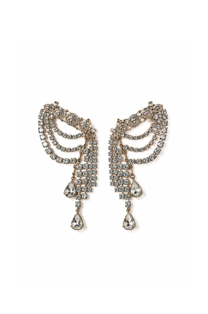 A pair of ornate DYLANLEX silver-tone dangle earrings adorned with clear rhinestones, featuring curved layered bands and teardrop-shaped drops, set against a plain white background.